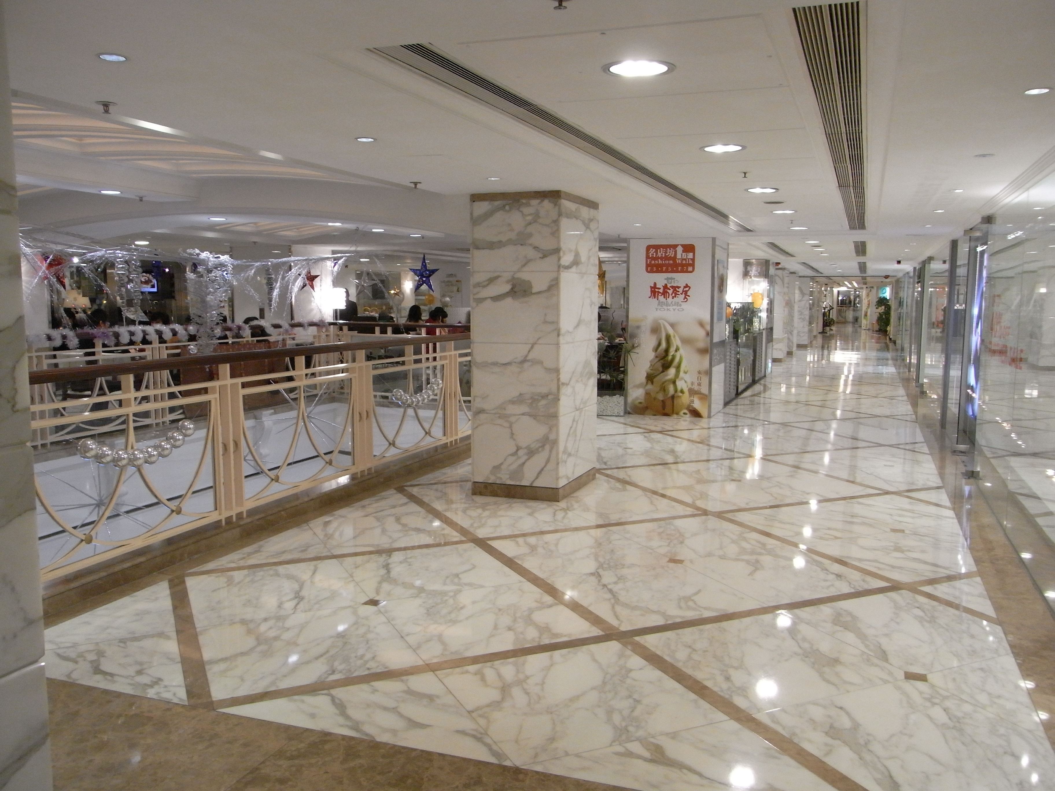 Shopping mall concourse with polished natural-stone floor and column cladding
