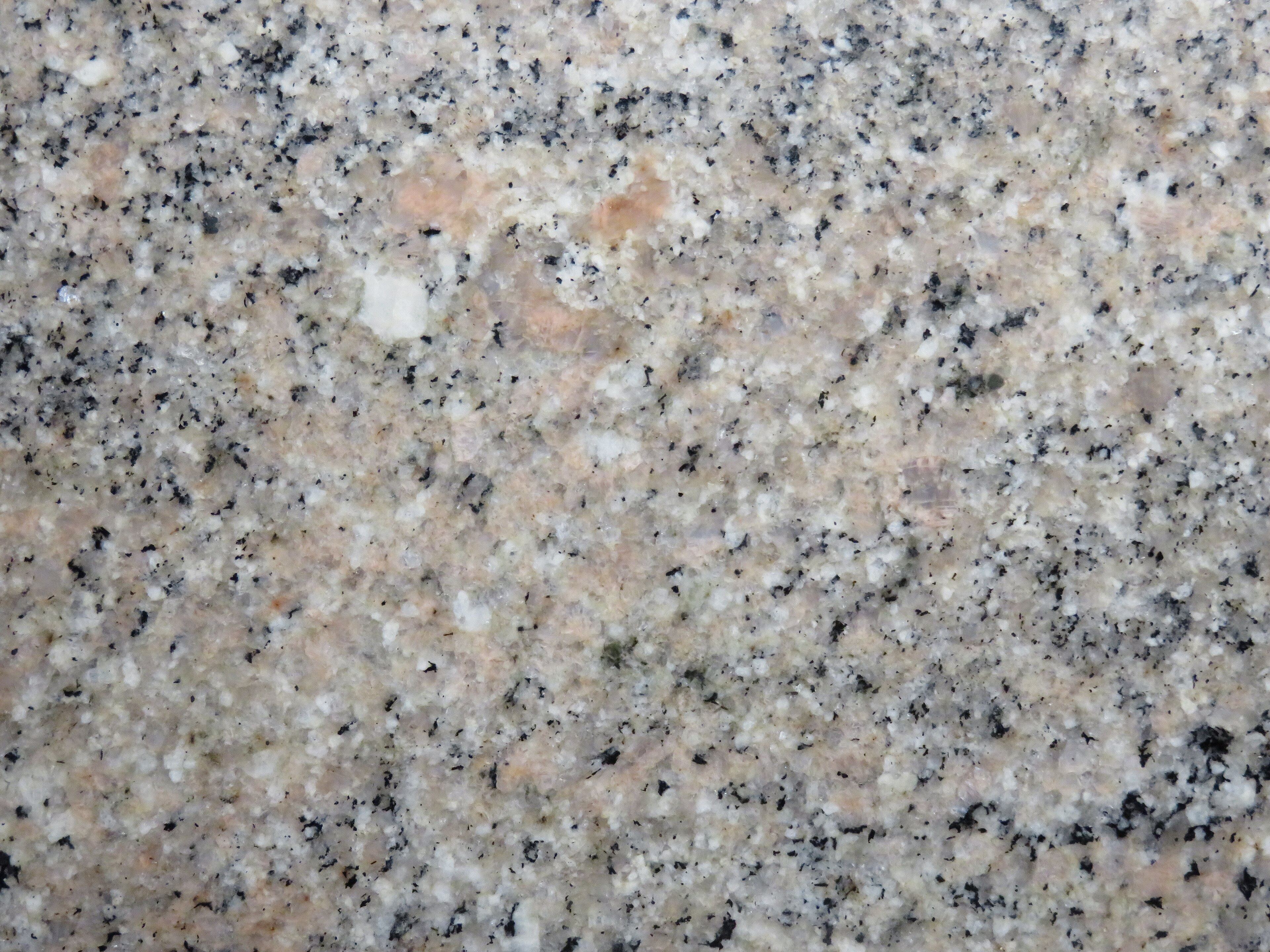 Polished granite surface reflecting light, with crisp mineral grains